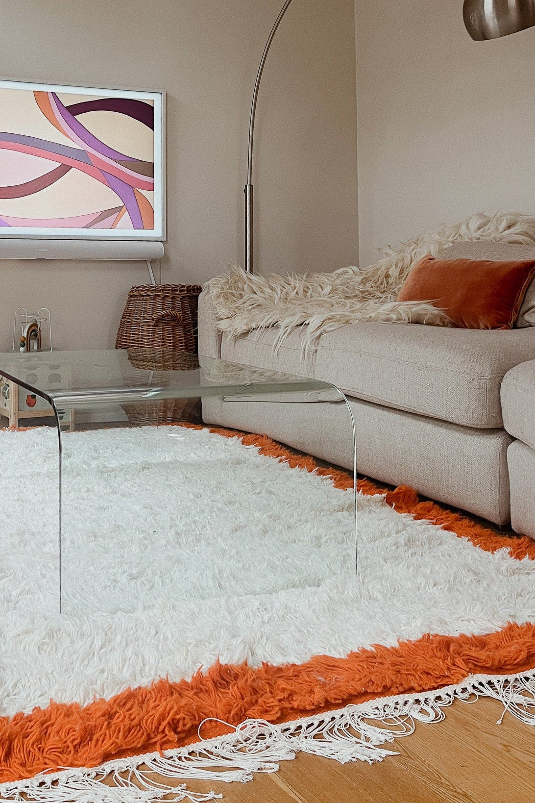 The Aisha handmade Berber rug styled in a modern living room, placed under a white sofa with warm-toned decor