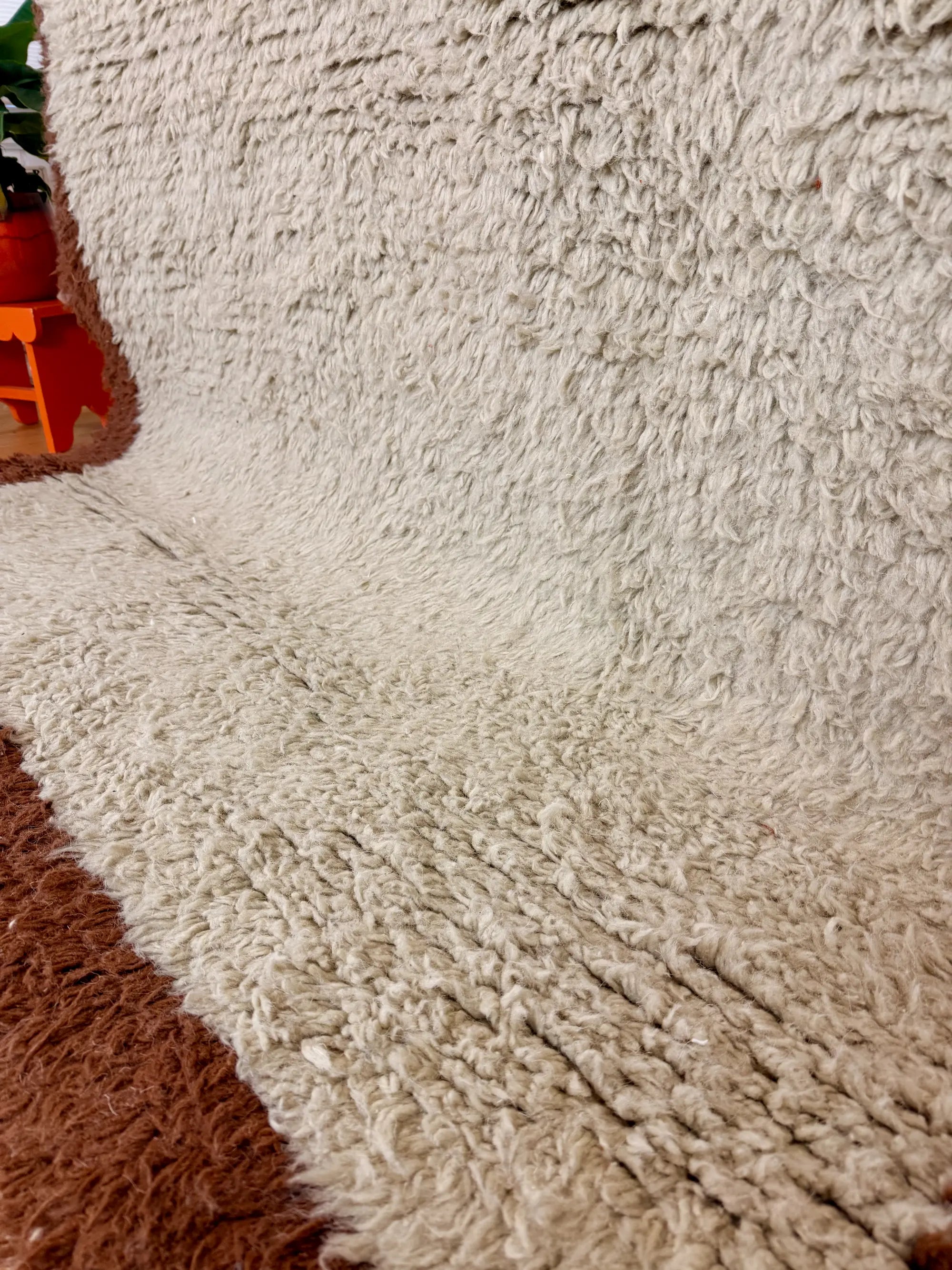 Macro close-up of the natural cream shaggy wool pile on the Aliyah Berber rug, showing the dense hand-knotted texture, handmade in Tunisia.