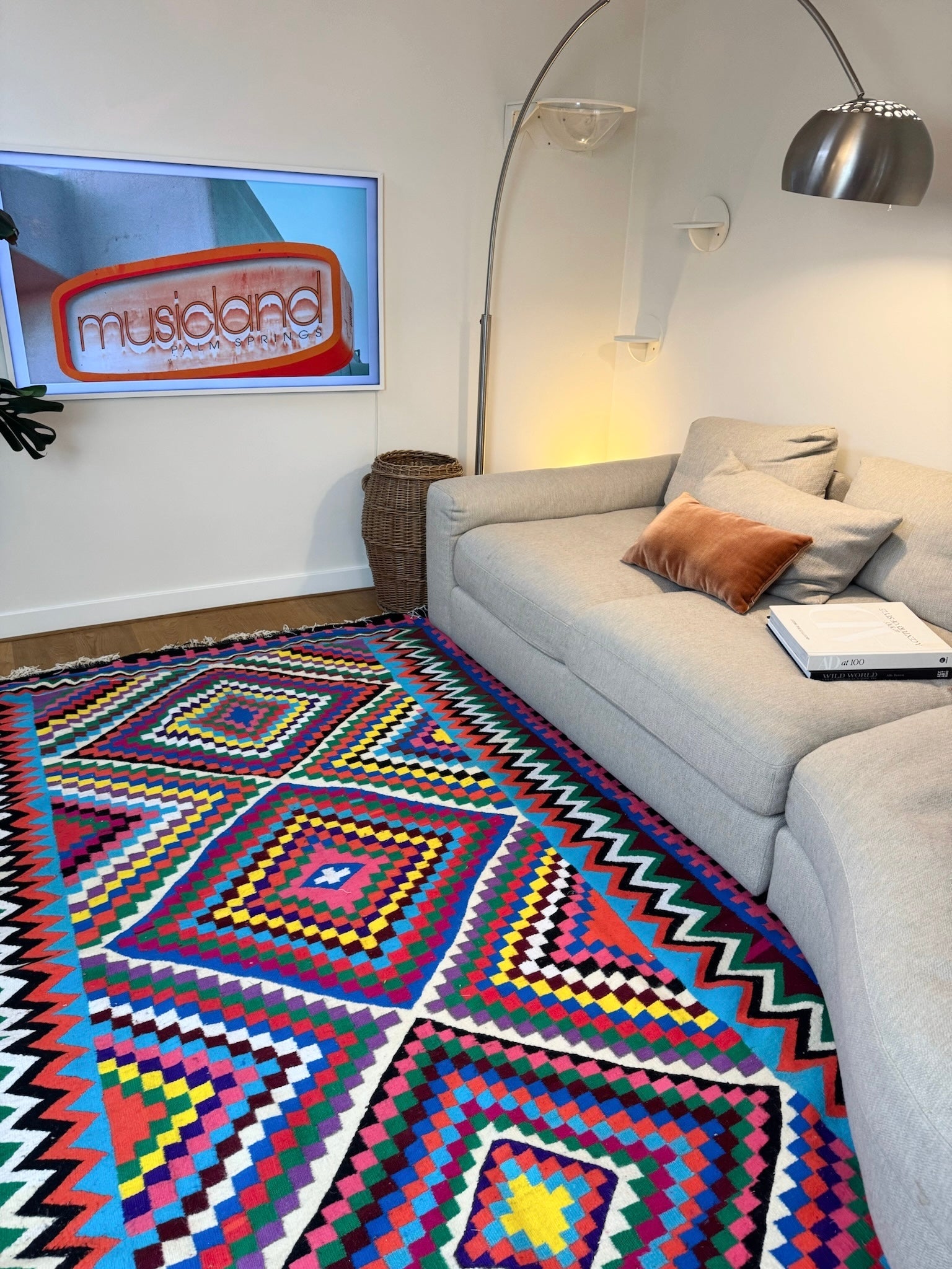Multicolor handmade wool rug styled in a modern living room with sofa.