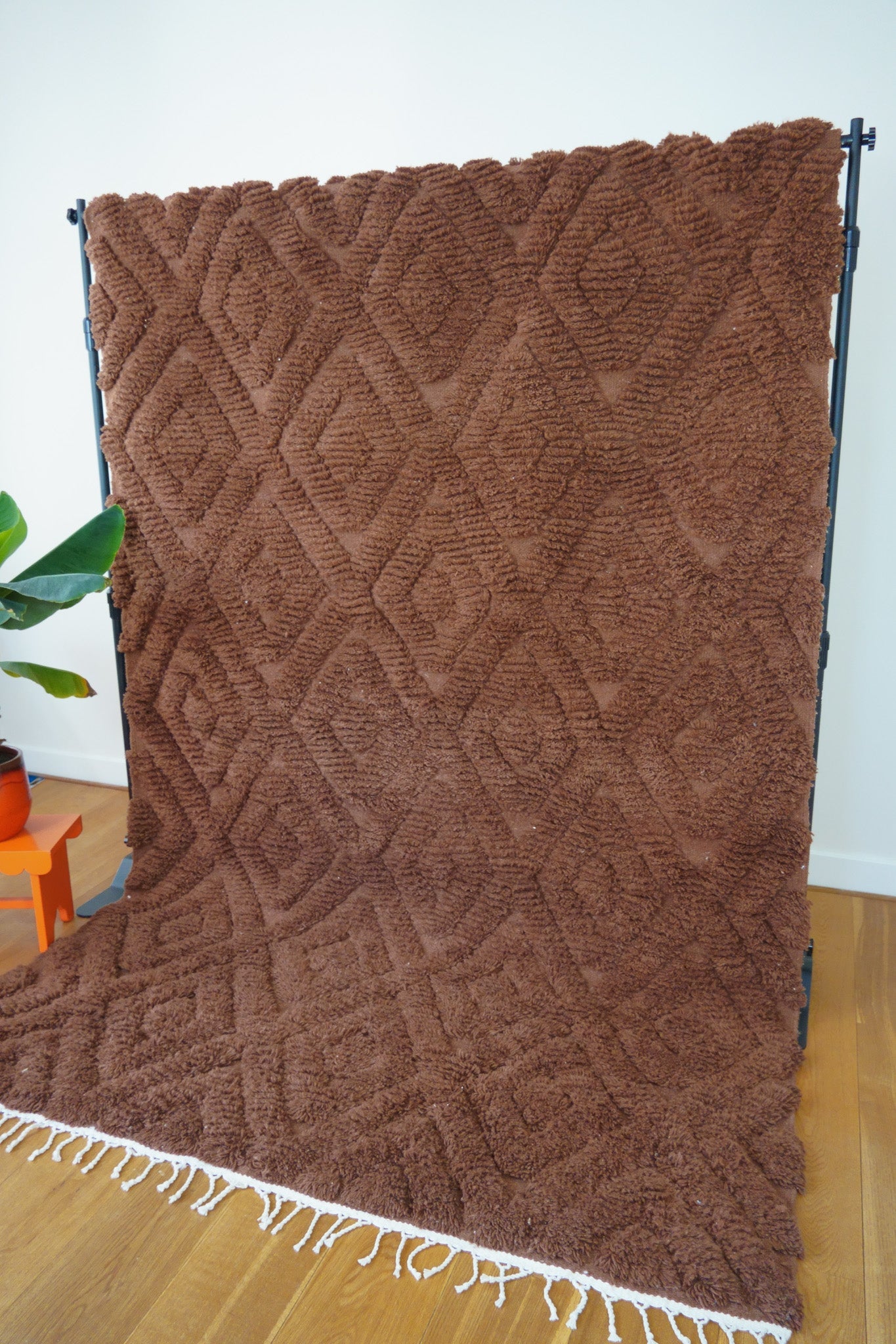 Side view of the Leila Berber rug showing soft shaggy texture and hand-knotted detail in rich brown wool