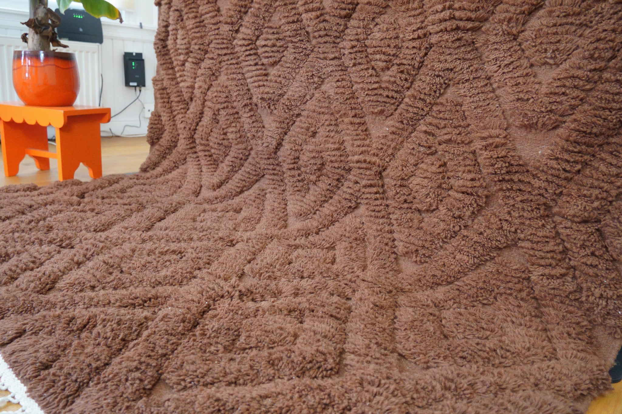 Close-up of the Leila rug’s raised diamond motif and plush hand-knotted wool in warm brown tone