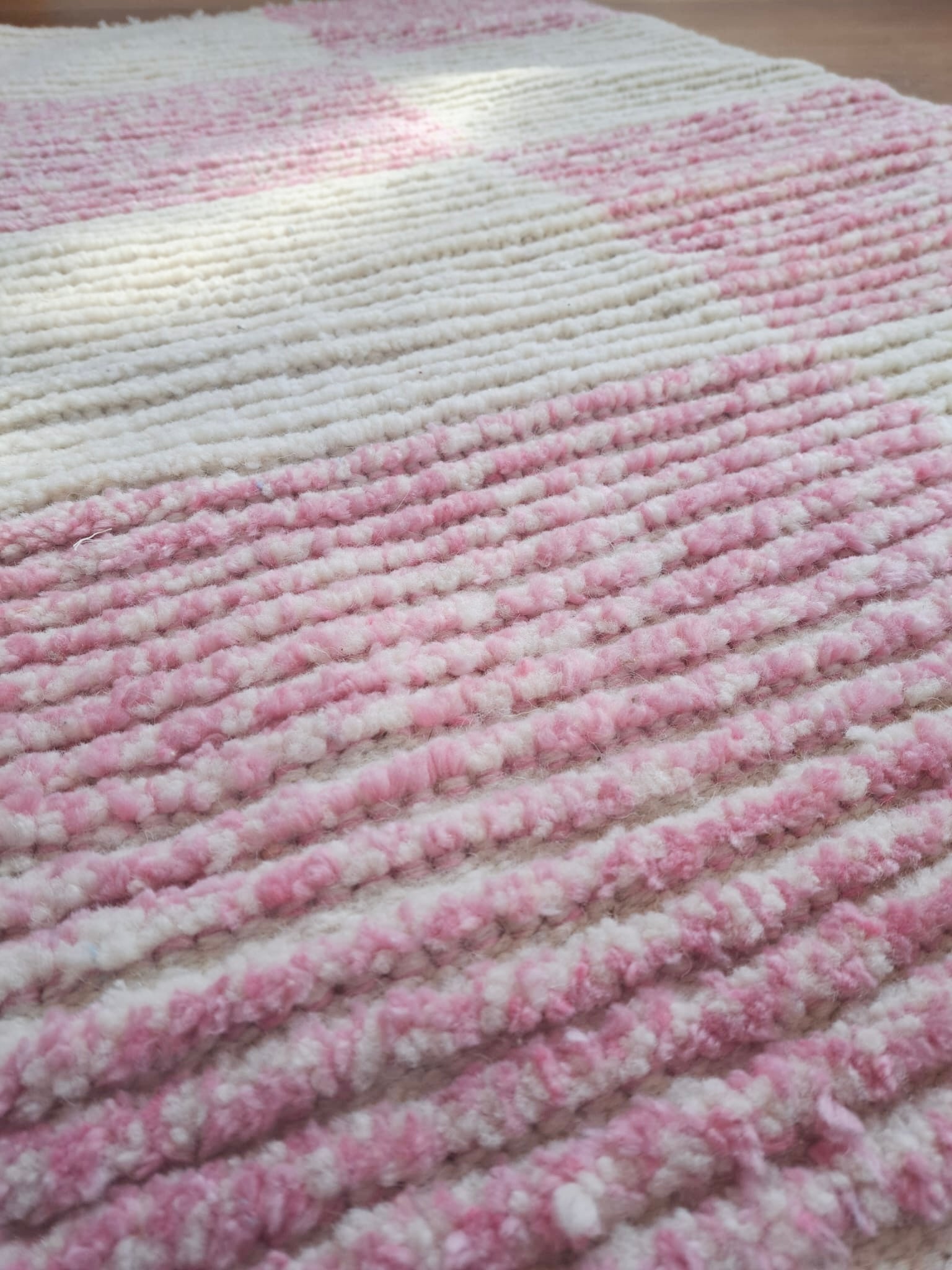 Extreme close-up of the Lina handmade wool rug showing the individual pink wool fibers and weave structure