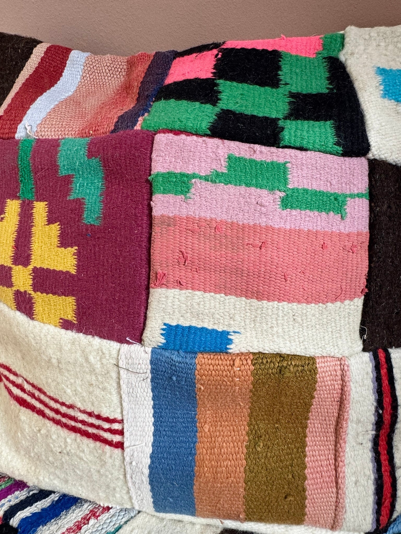Close-up of Rania handmade patchwork floor cushion cover with colorful motifs.
