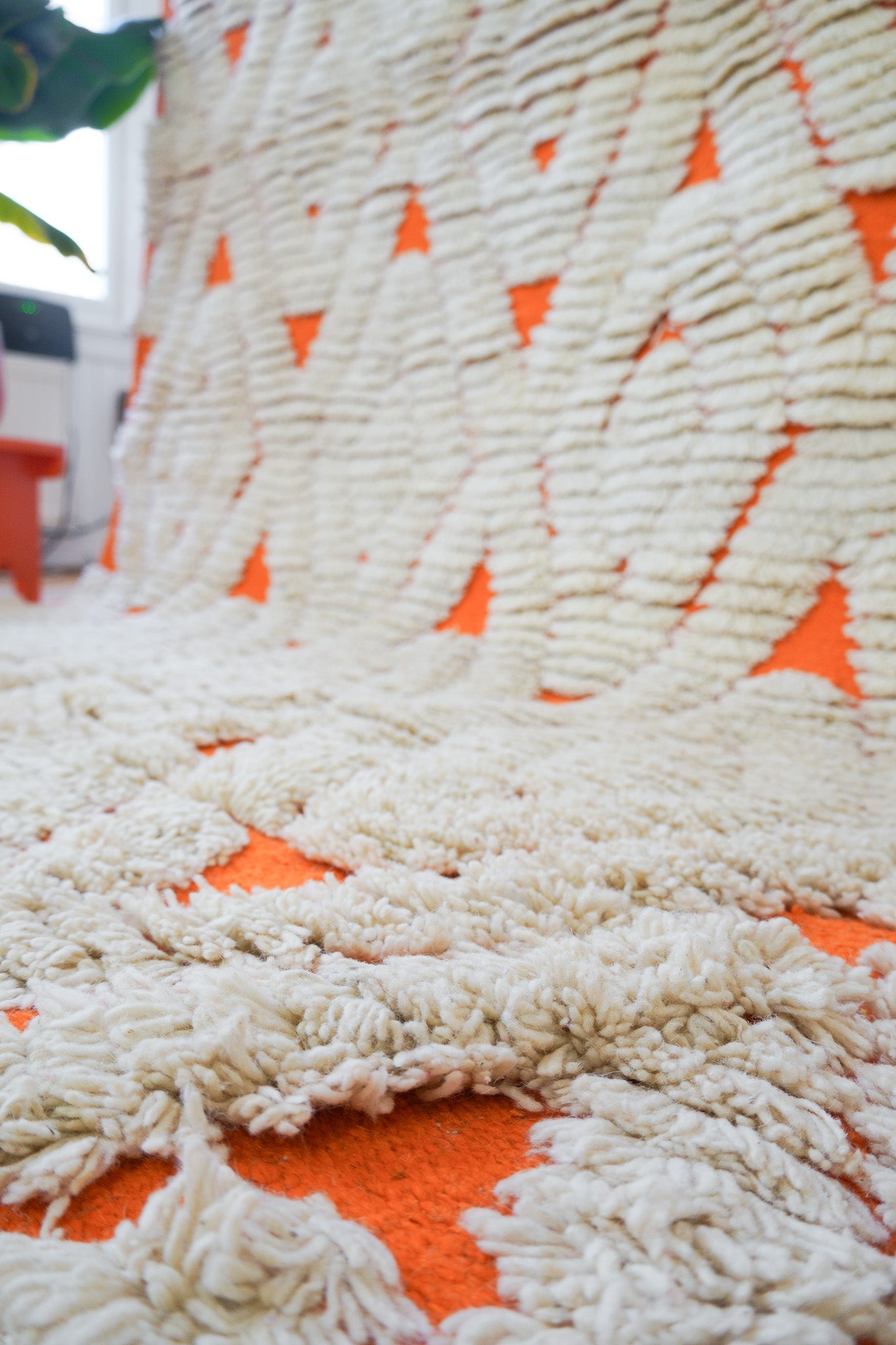 Edge and fringe detail of the orange & cream handmade wool rug