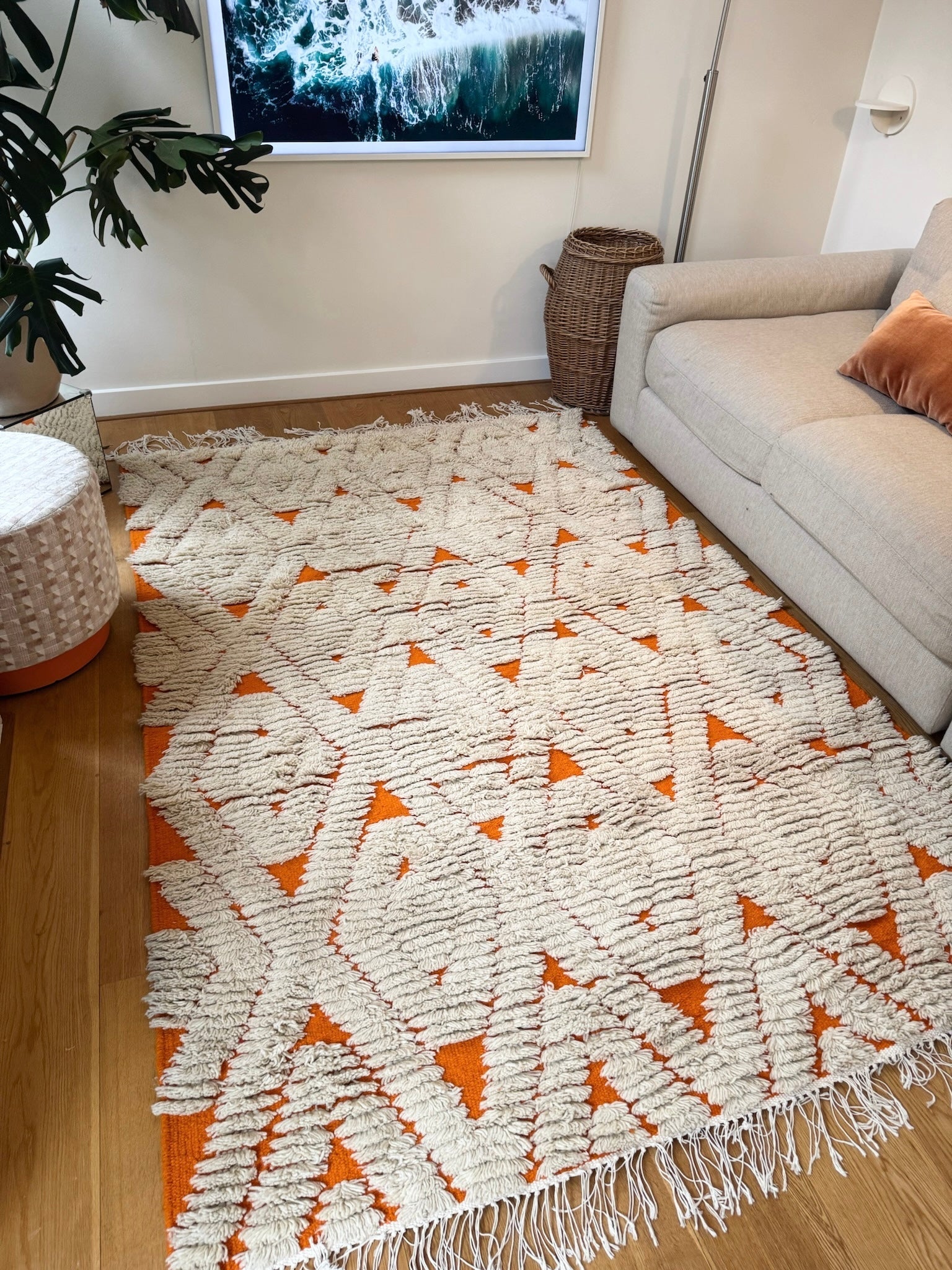 Flat view of the orange & cream diamond wool rug on wooden floor in living room.