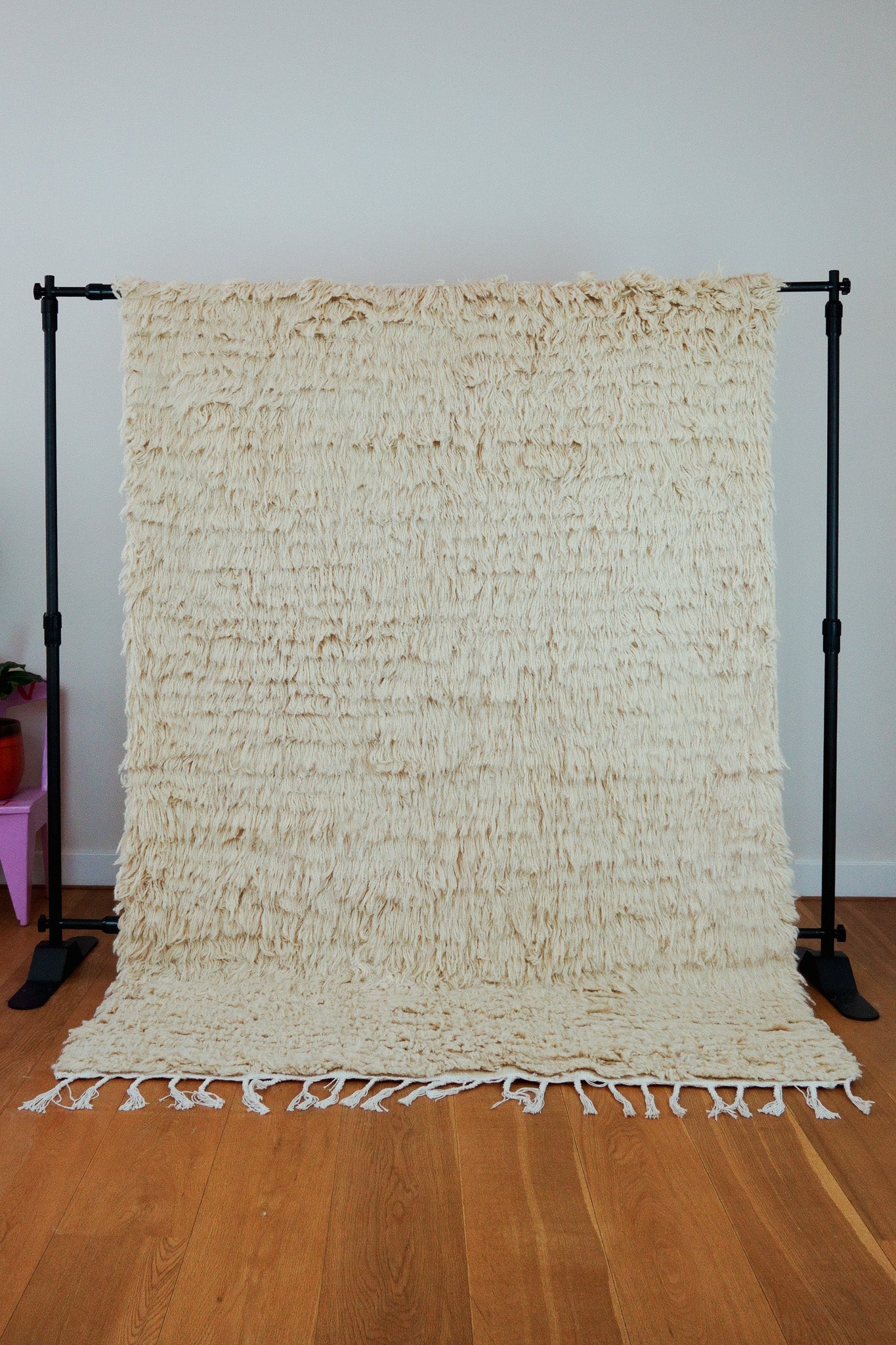 Full view of the Samira handmade cream Berber wool rug (150 × 200 cm), upright on wooden floor