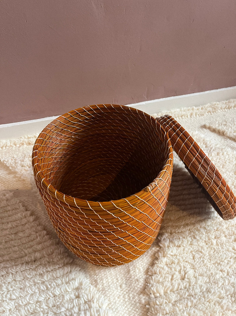 Open top view showing orange woven pattern inside basket on a texture ground.