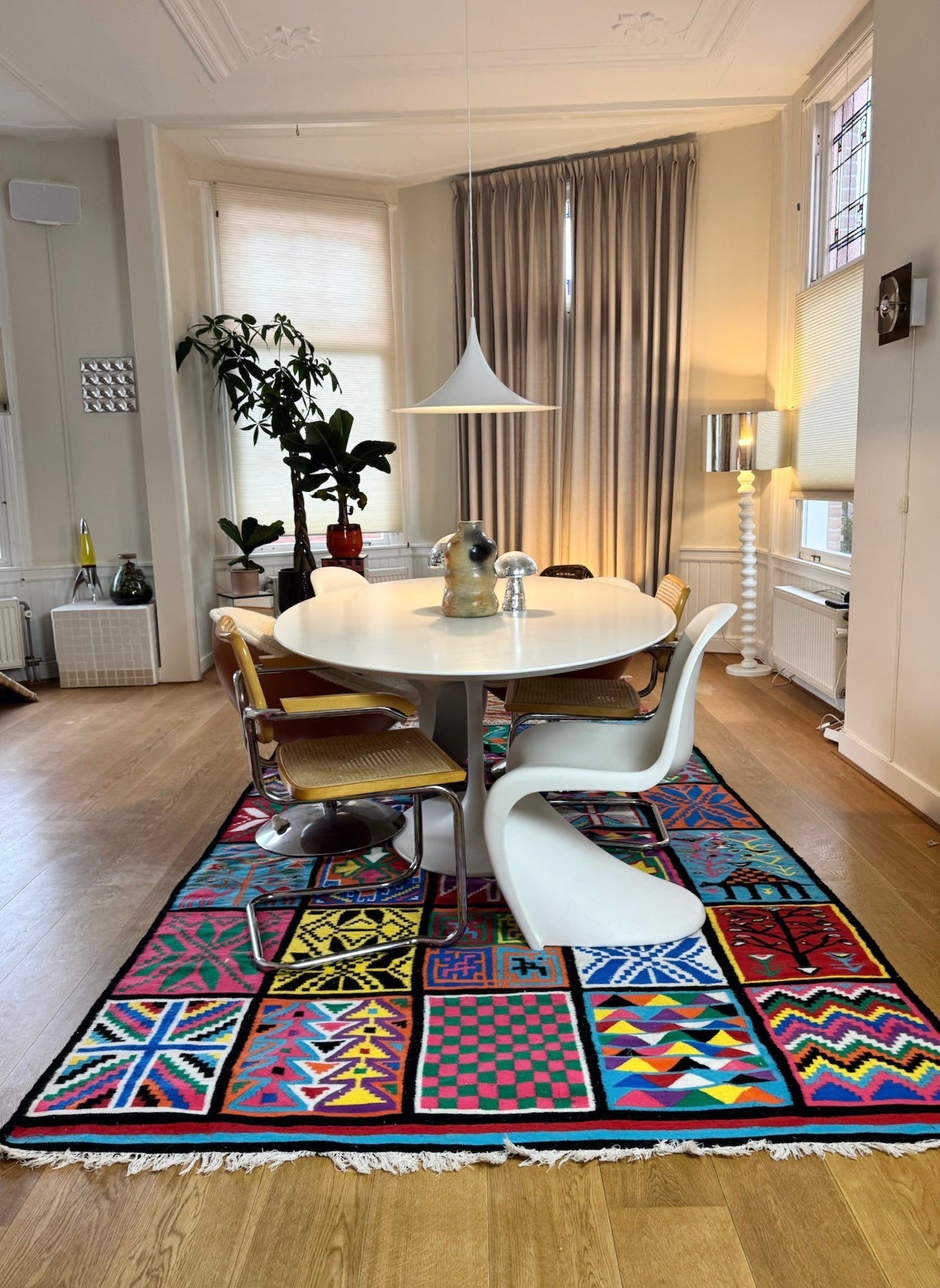 Multicolor patchwork wool rug styled in a dining room setting.