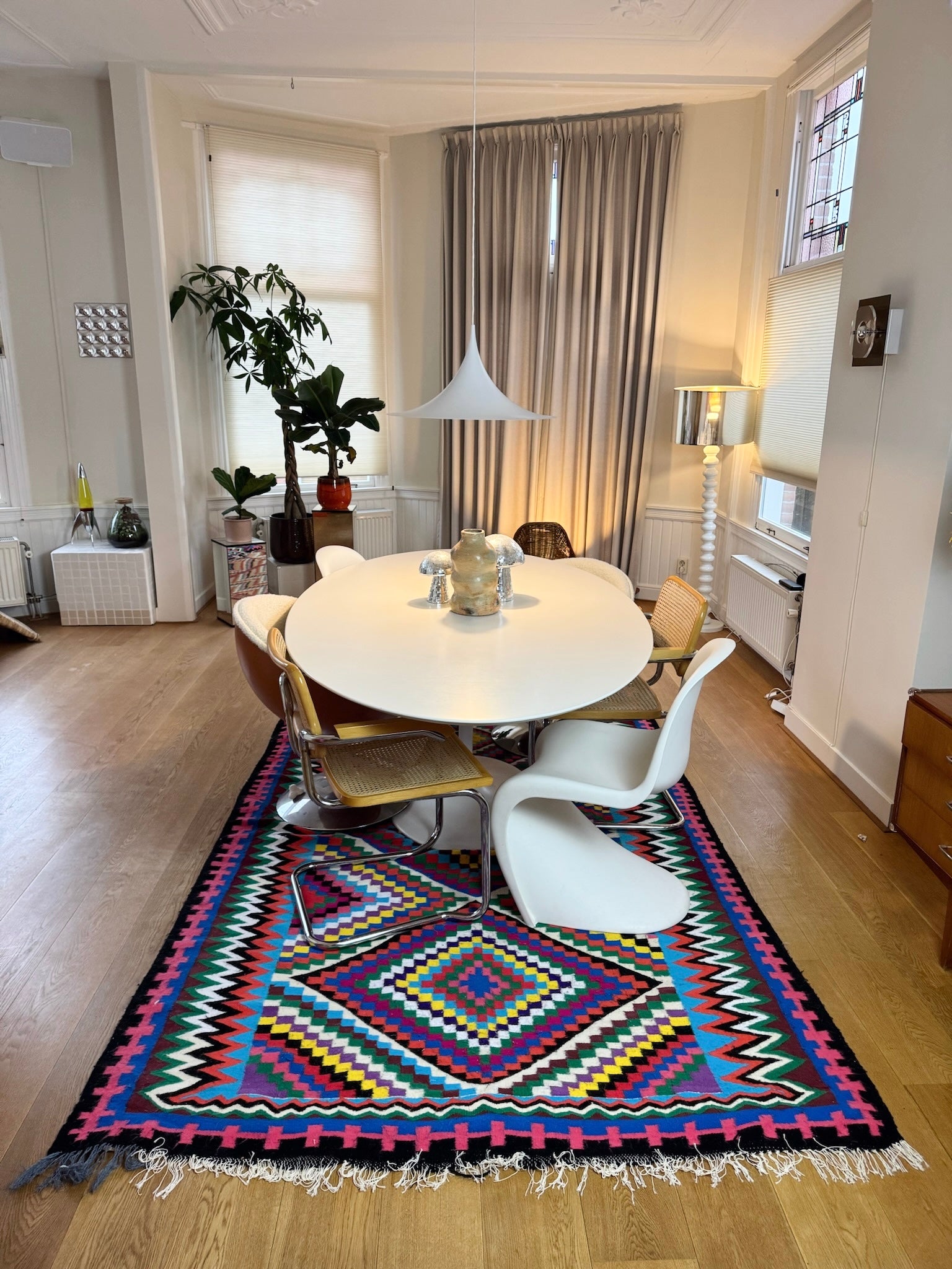Multicolor handmade wool rug styled in dining room setting.