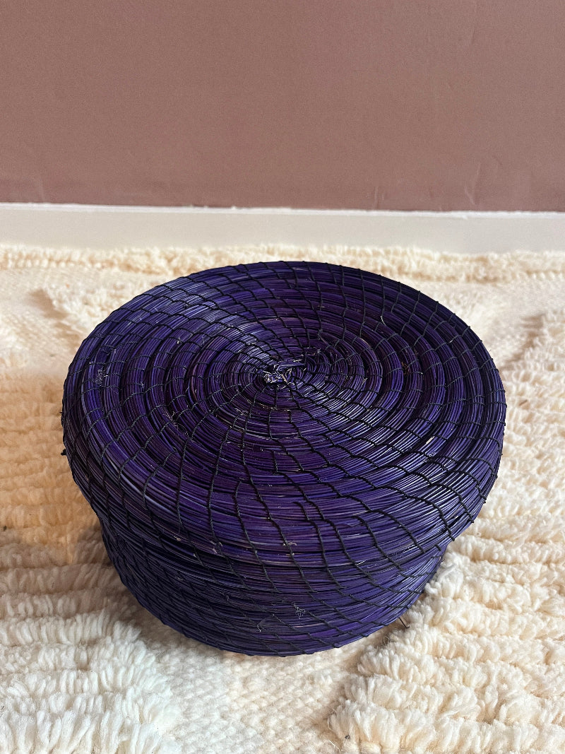 Overhead view of Karima handmade straw basket in deep purple.