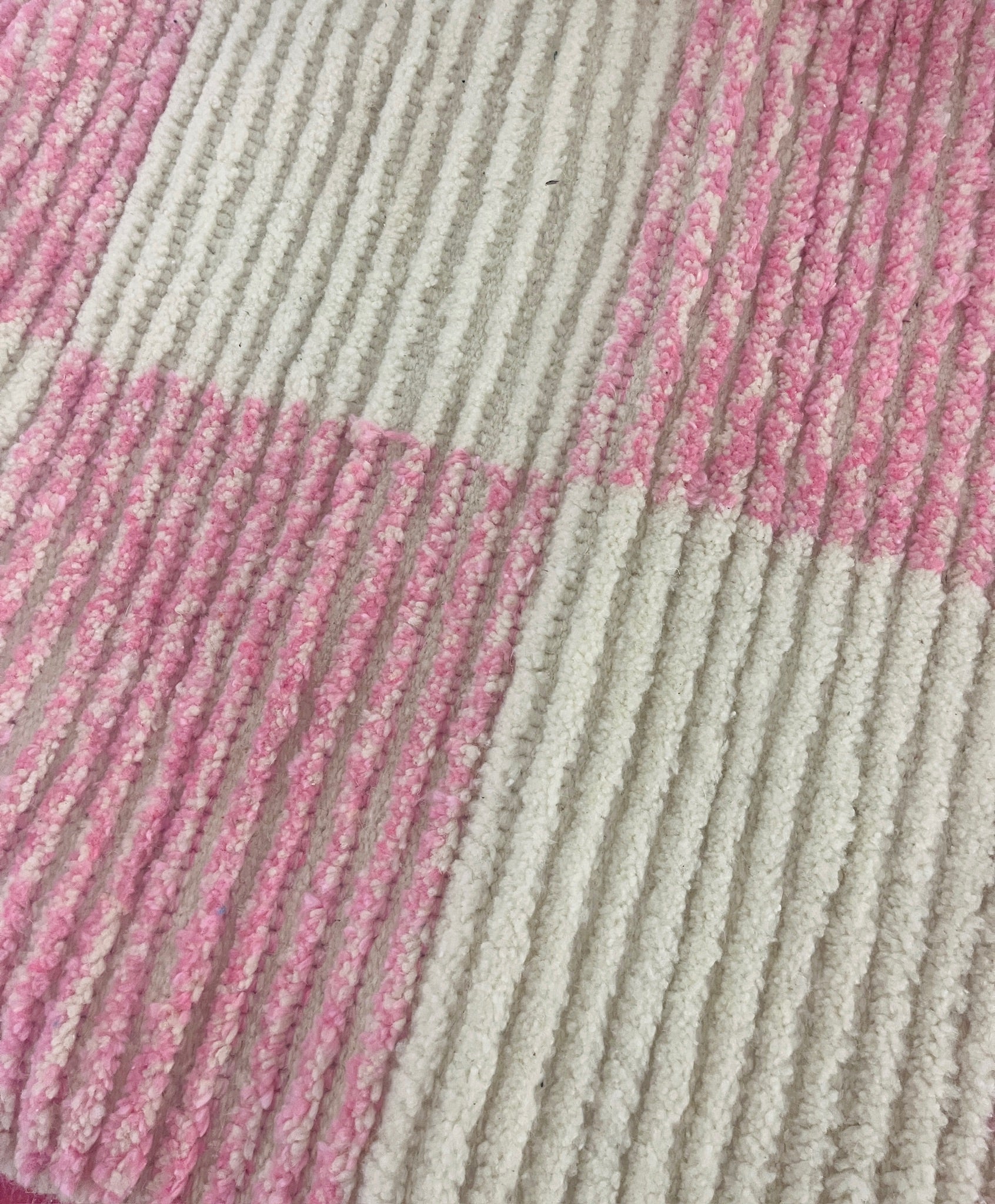 Detailed close-up of the Lina rug in lower lighting, showing the handwoven texture and checkered pattern in soft wool