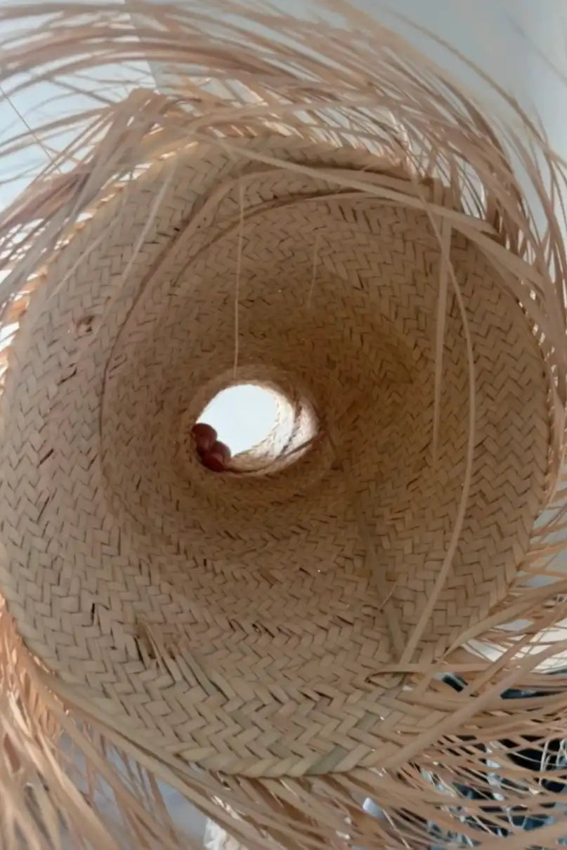 Inside view of handwoven palm fibre lampshade showing weaving craftsmanship.