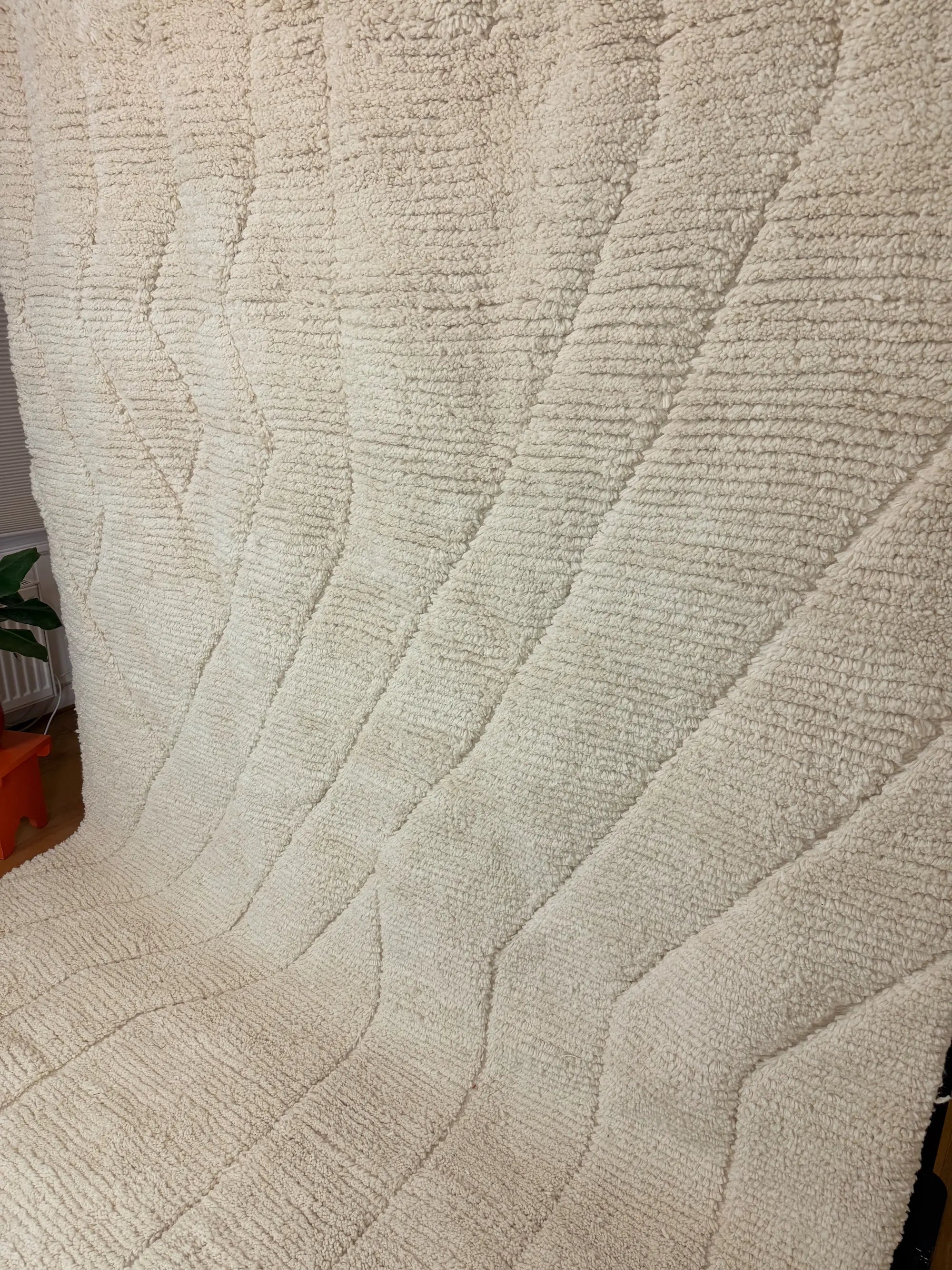 Beya handmade Berber wool rug, side view showing the full raised line pattern across the natural ivory wool surface, handmade in Tunisia.