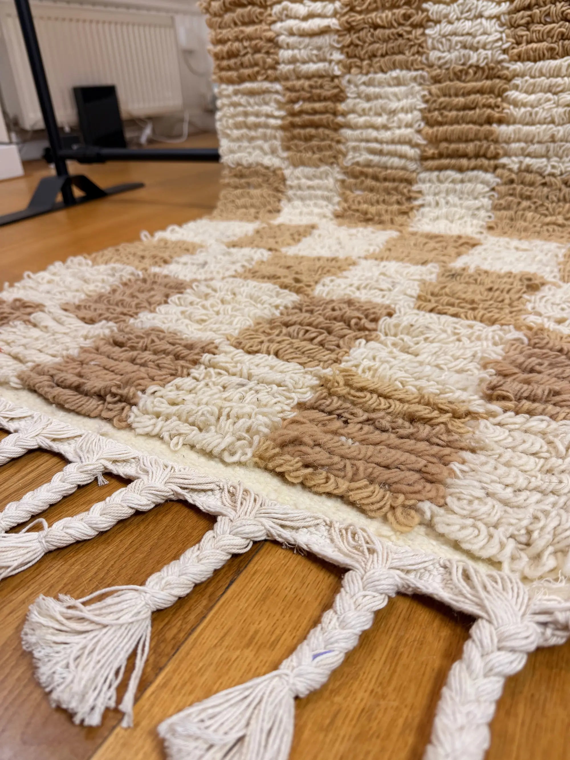 Close-up of the natural ivory hand-knotted fringe and checkerboard pattern on the Sabrine handmade Berber wool runner, Tunisia.